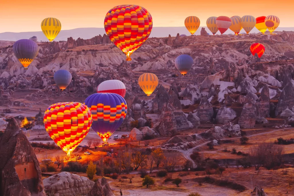 Vista panorámica y vibrante del vuelo de globos aerostáticos en el valle de Capadocia