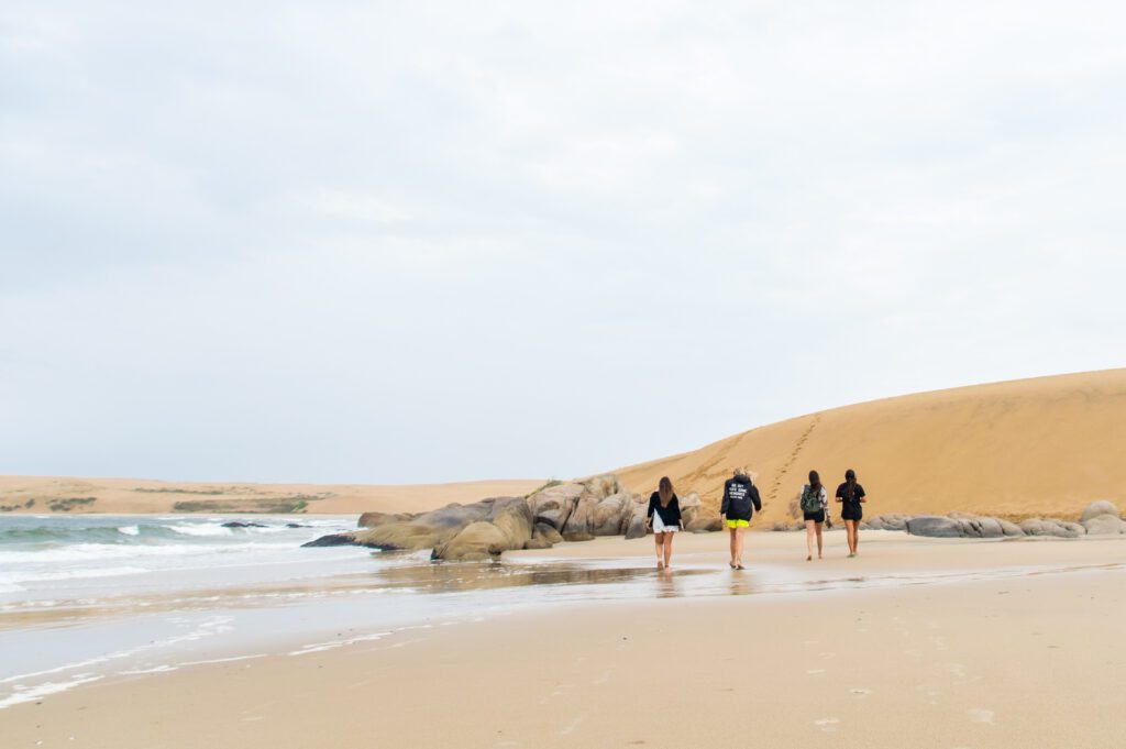 Mujer caminando por la playa cerca de las dunas – Barra de Valizas, Uruguay.