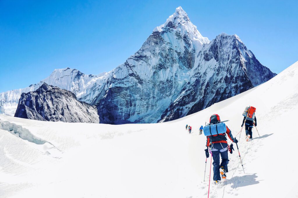Grupo de escaladores llegando a la cima del Everest en Nepal. Trabajo en equipo.