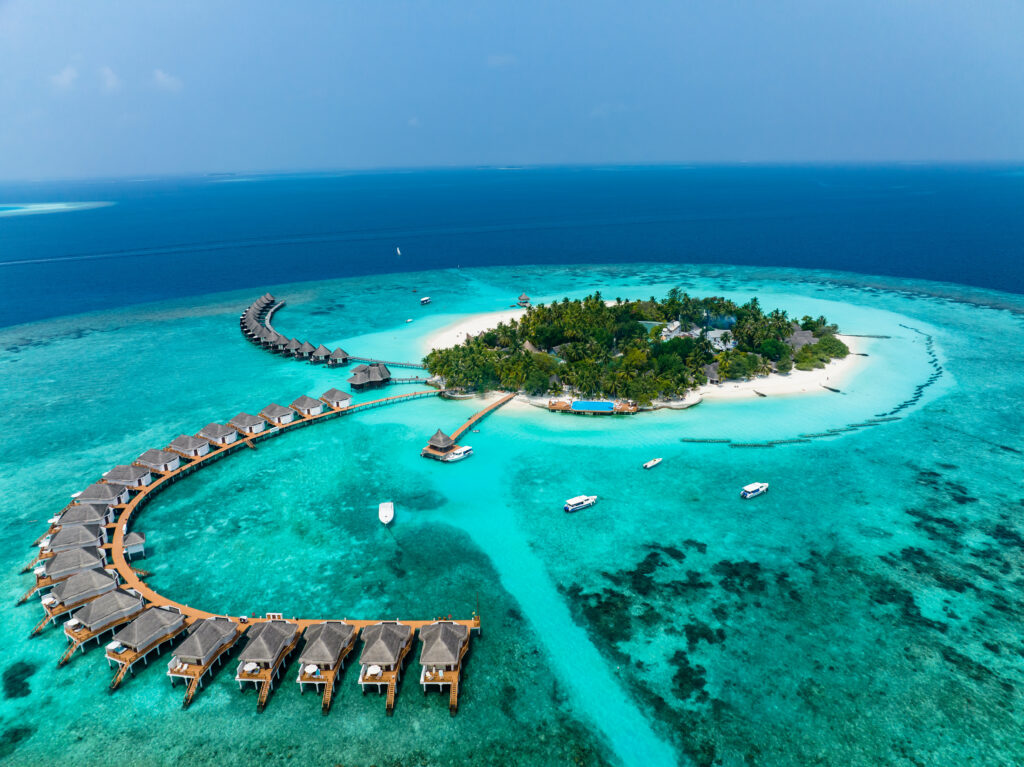 Vista aérea, Maldivas, atolón de Malé del Norte, océano Índico, Thulhagiri Island Resort con bungalós sobre el agua.