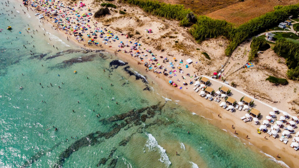 Vista aérea de la playa de Pescoluse, conocida como las «Maldivas de Salento», en el sur de Italia; playa de Apulia de aguas turquesas en verano; un destino vacacional idílico a orillas del mar Jónico.