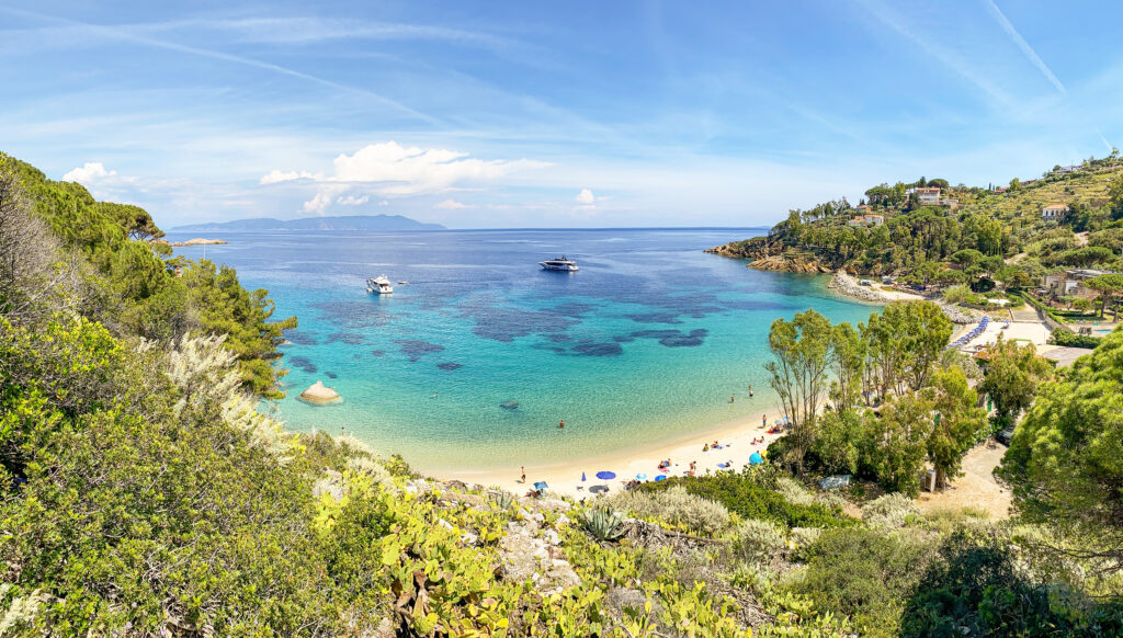 Vista de la playa de Cannelle (Spiaggia delle Cannelle), cerca de Giglio Porto, con vistas al mar Mediterráneo y a una hermosa bahía de aguas azules en Isola del Giglio —una isla del archipiélago toscano—, en la provincia de Grosseto, Toscana, Italia.