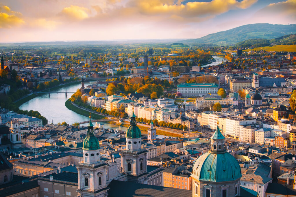 Hermosa vista panorámica aérea de la histórica ciudad de Salzburgo en otoño, con el río Salzach bajo una preciosa luz dorada al atardecer y los colores otoñales; Salzburger Land, Austria.