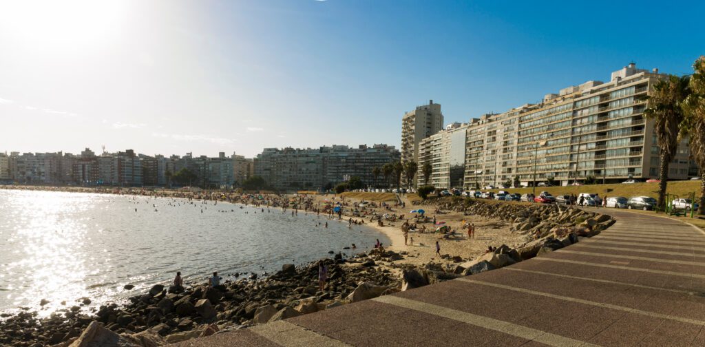 Hermoso atardecer en la playa de Pocitos con bañistas en un día de verano en Montevideo, Uruguay.