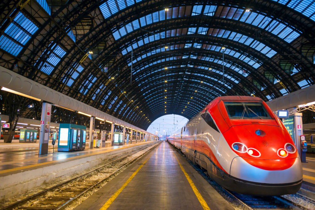 Estación de tren con un tren al atardecer en Milán, Lombardía (Italia).
